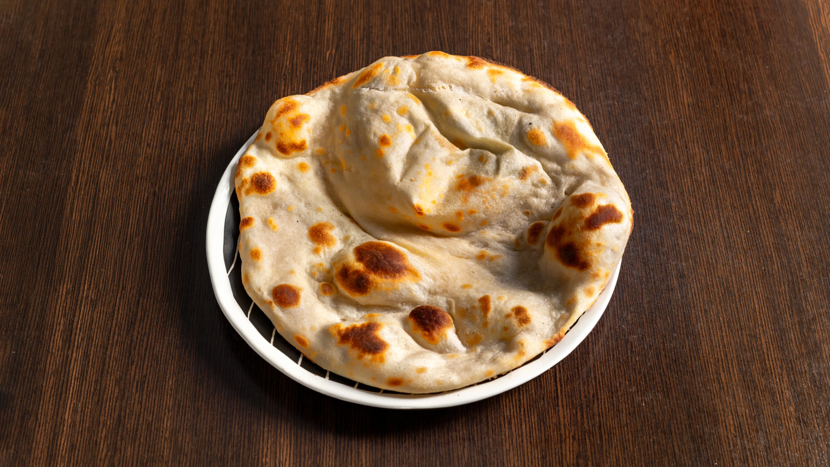 Naans indiens frais sur assiette blanche